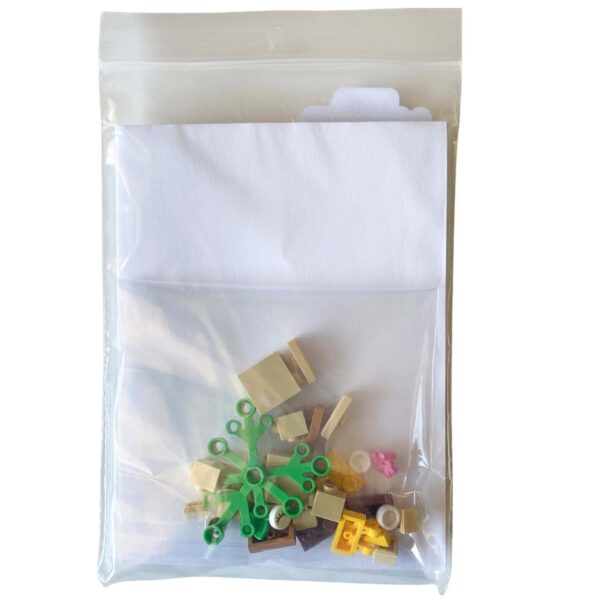Individual LEGO pieces for the mini owl brick build laid out beside the greeting card